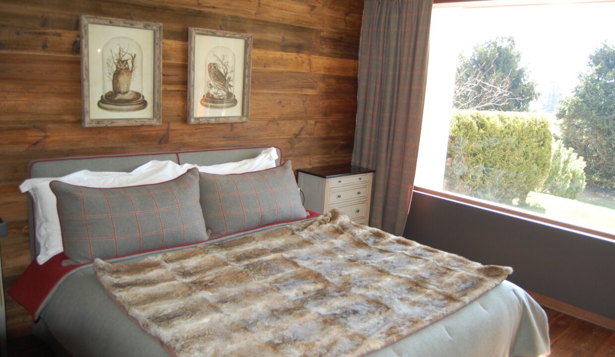 Gemütliches Schlafzimmer mit rustikaler Holzverkleidung