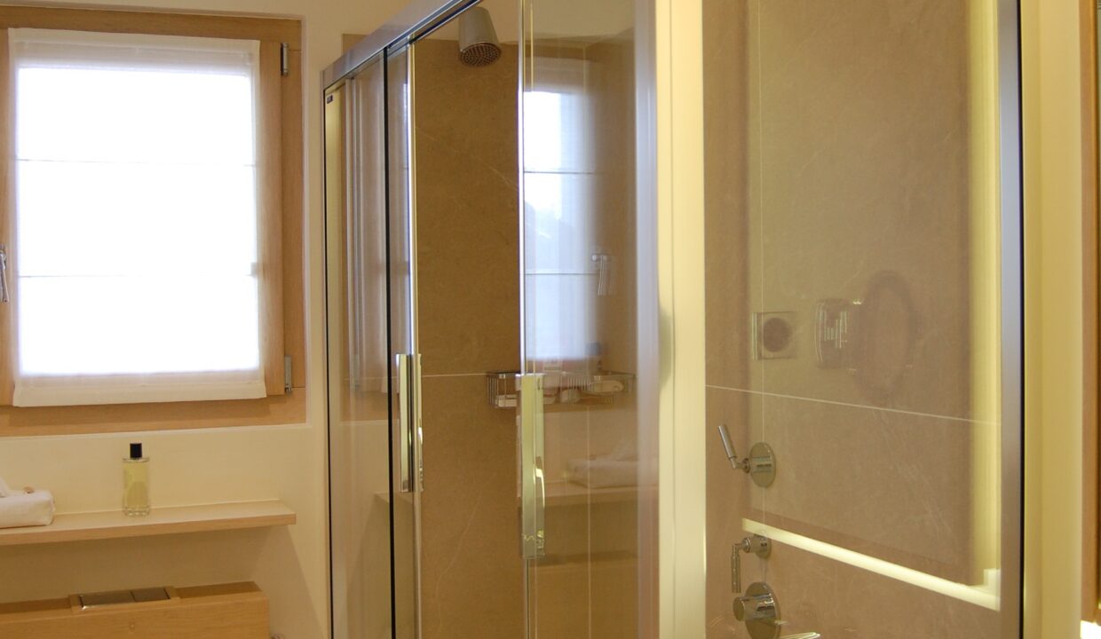 Modernes Badezimmer mit verglaster Dusche und Fenster
