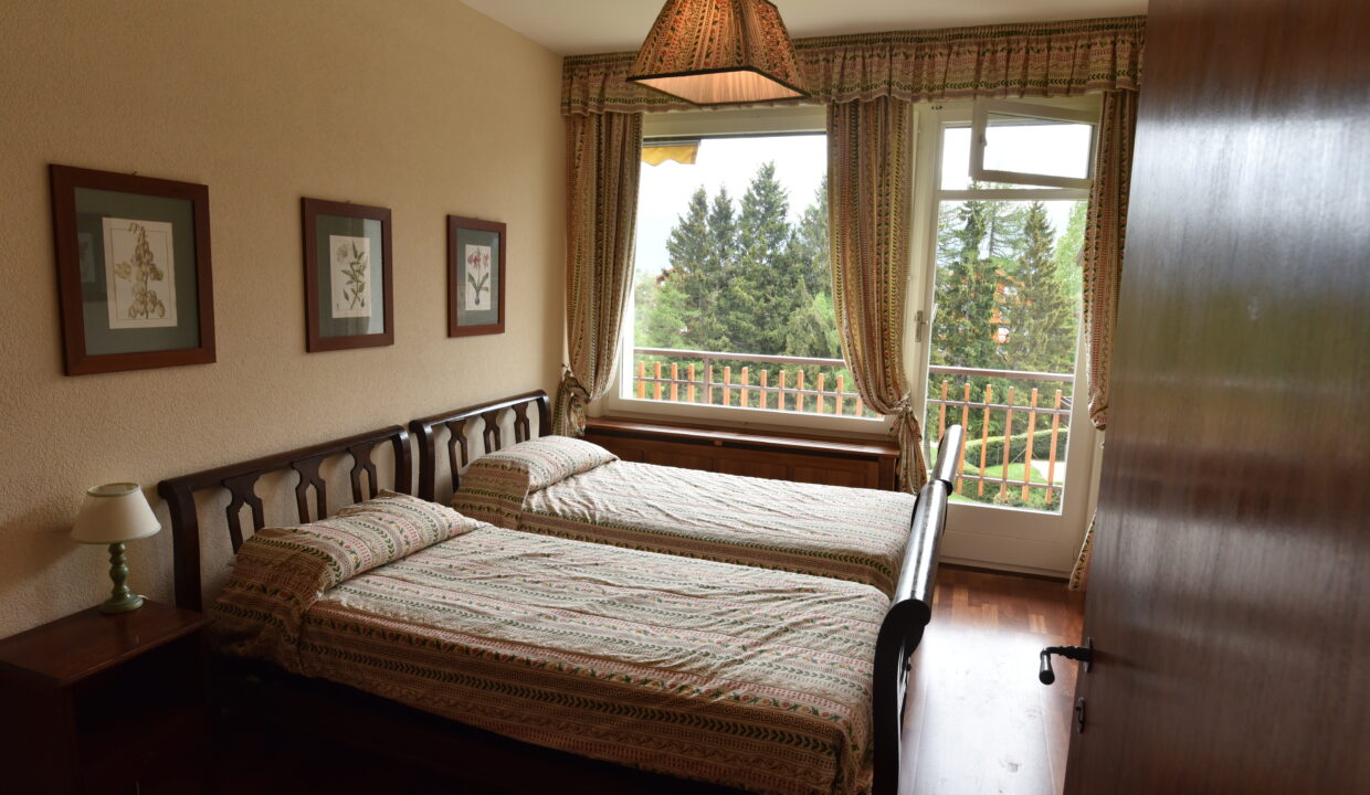 Schlafzimmer mit zwei Einzelbetten und Balkonblick