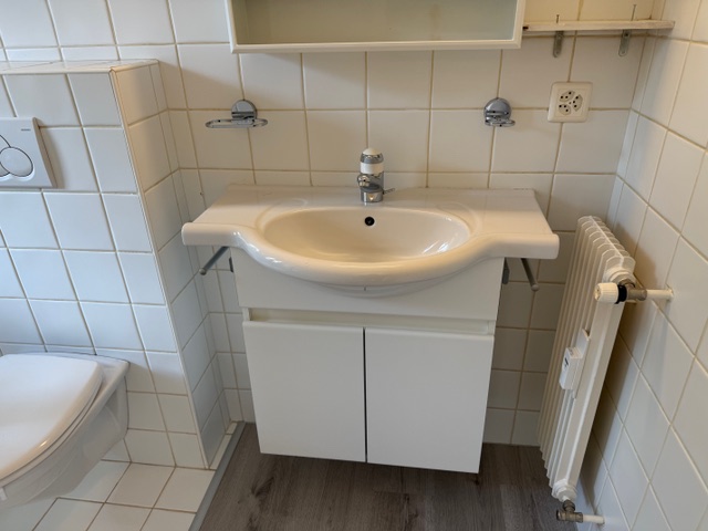 Kleines Badezimmer mit Waschbecken und WC