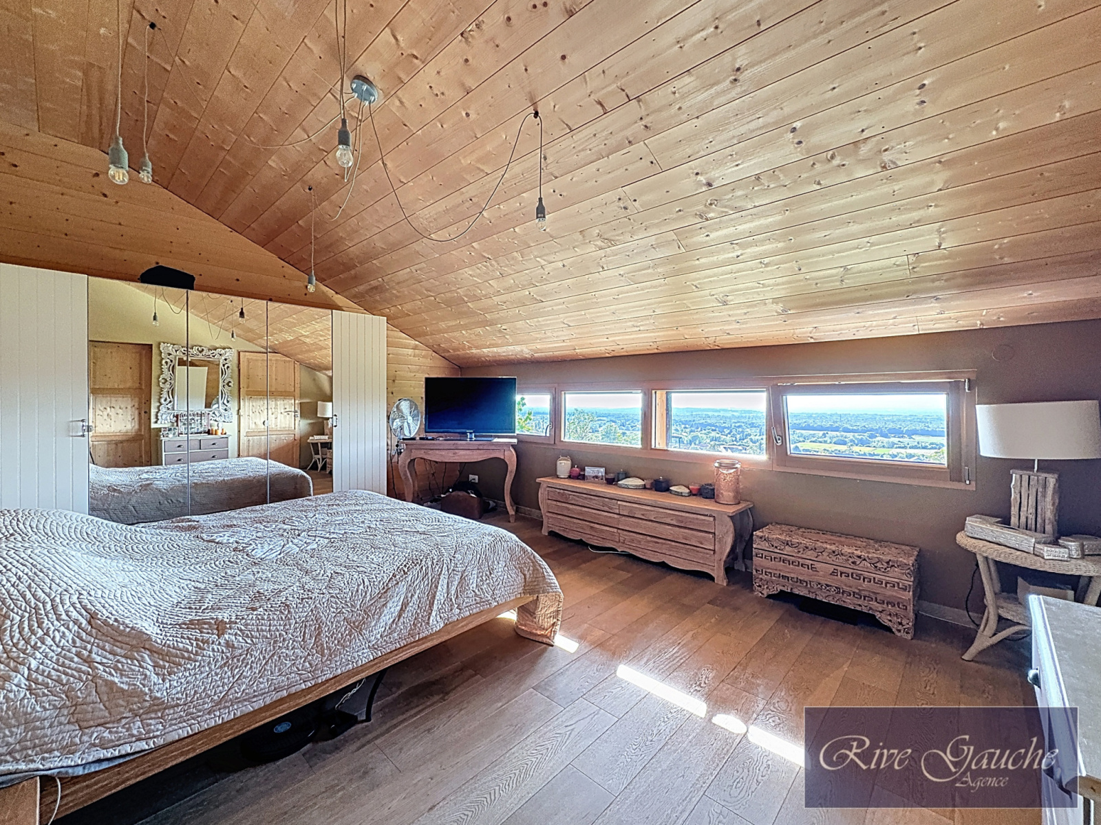 Schlafzimmer mit Dachschräge und Panoramafenster