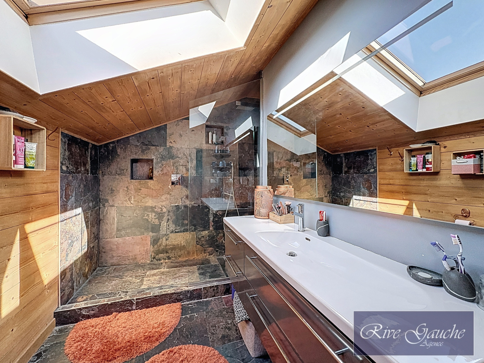 Modernes Badezimmer mit Dachfenstern und Natursteinoptik