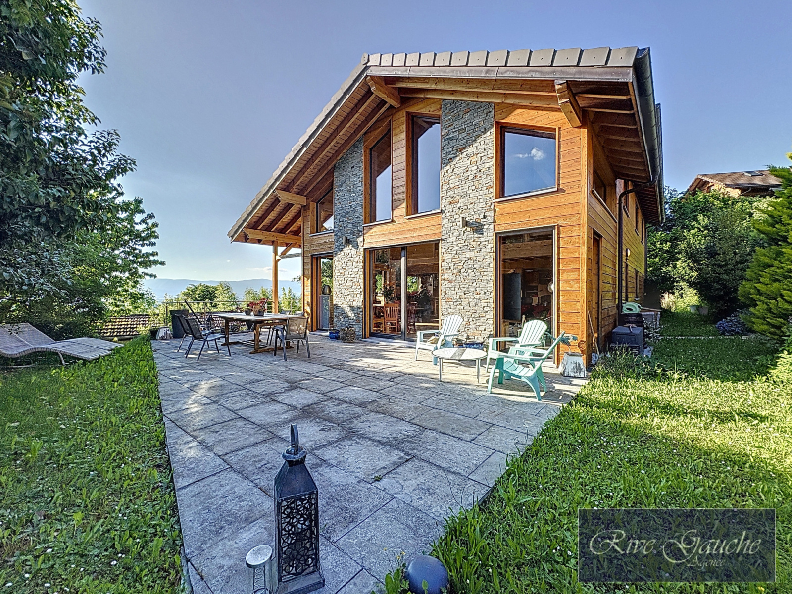 Außenansicht eines Holzhauses mit Terrasse und Garten