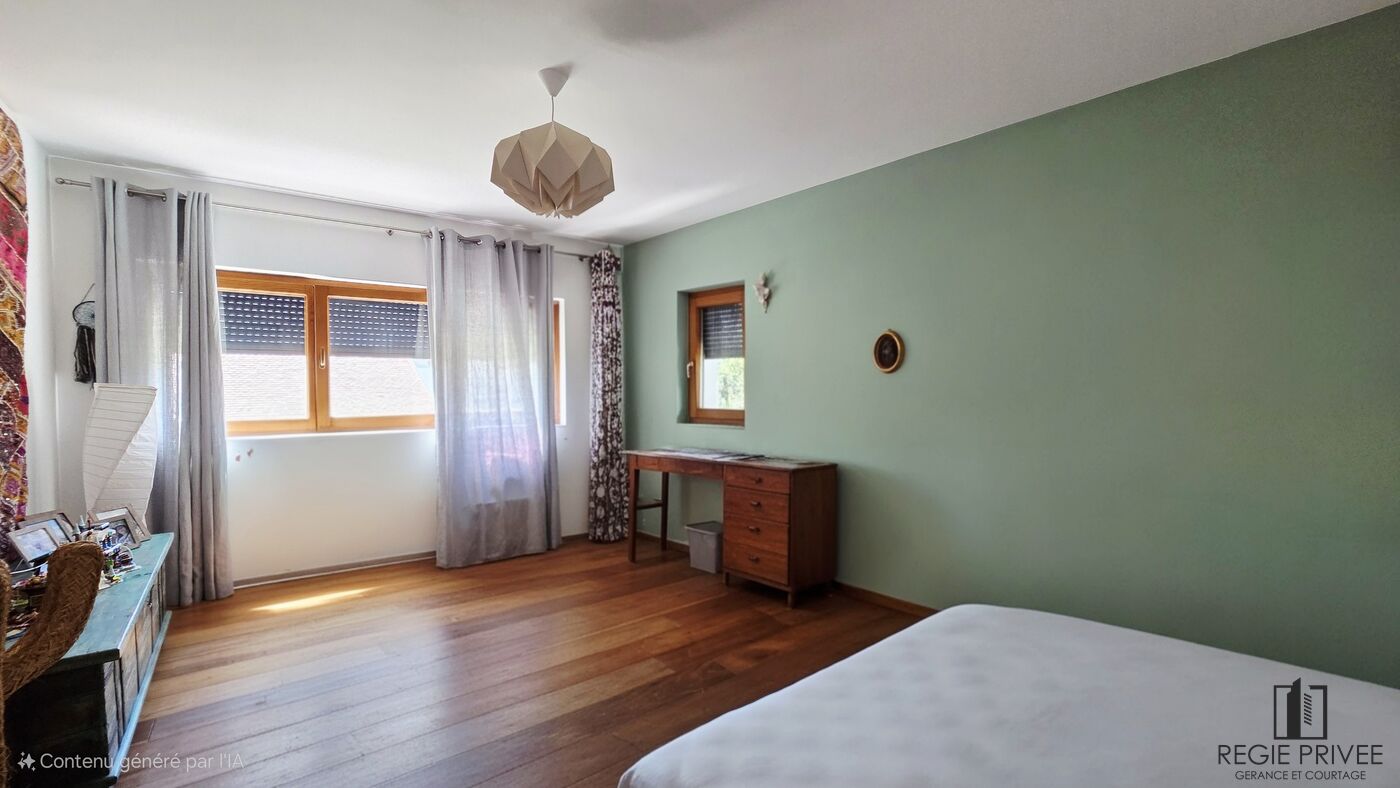 Helles Schlafzimmer mit Holzfenster und grün gestrichener Akzentwand