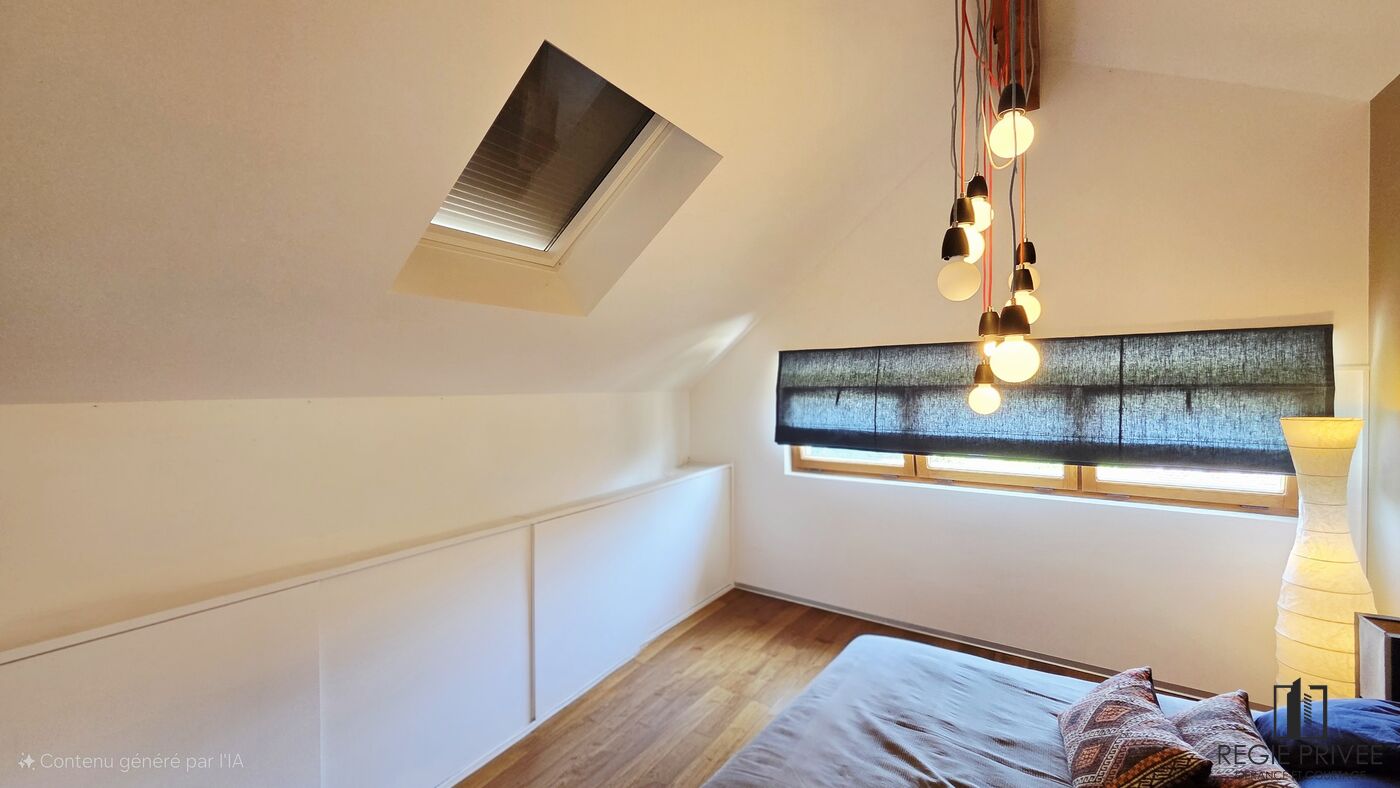 Helles Dachgeschoss-Schlafzimmer mit Dachfenster und Pendelleuchten
