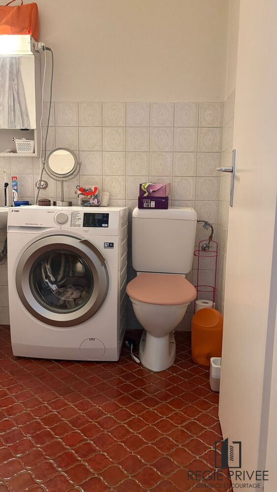 Kleines Badezimmer mit Waschmaschine und Toilette