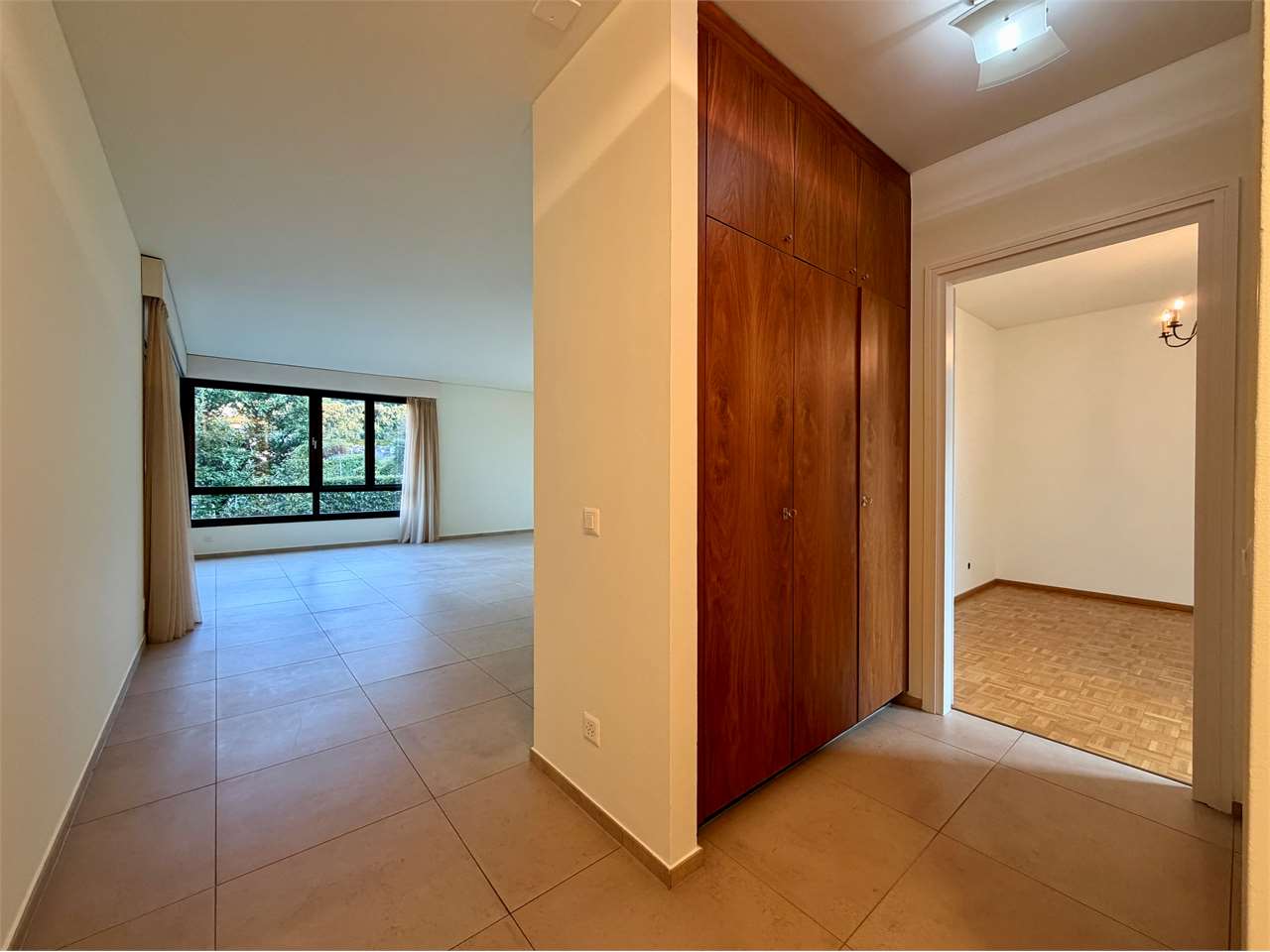 Flur mit Blick in einen Wohnraum und ein angrenzendes Zimmer