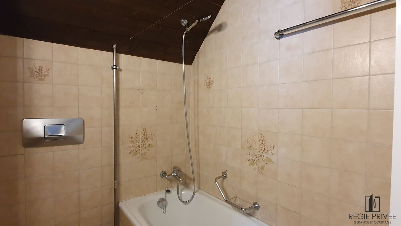 Badezimmer mit Badewanne und beigen Fliesen