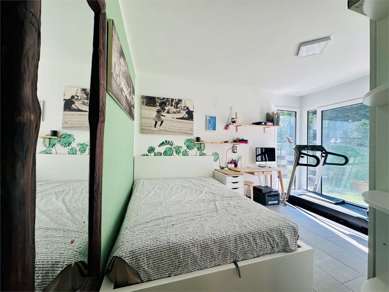 Helles Schlafzimmer mit Arbeitsplatz und Blick in den Garten