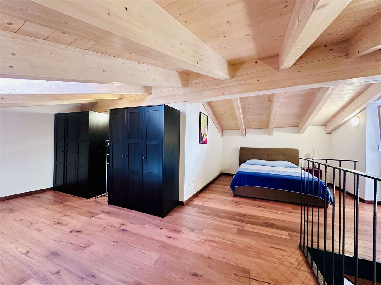 Dachgeschoss-Schlafzimmer mit sichtbaren Holzbalken