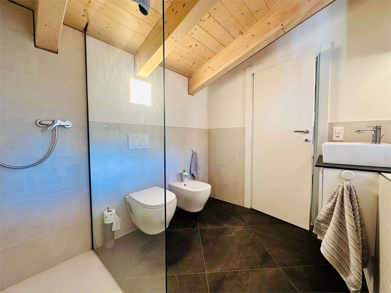 Modernes Badezimmer mit Holzbalkendecke