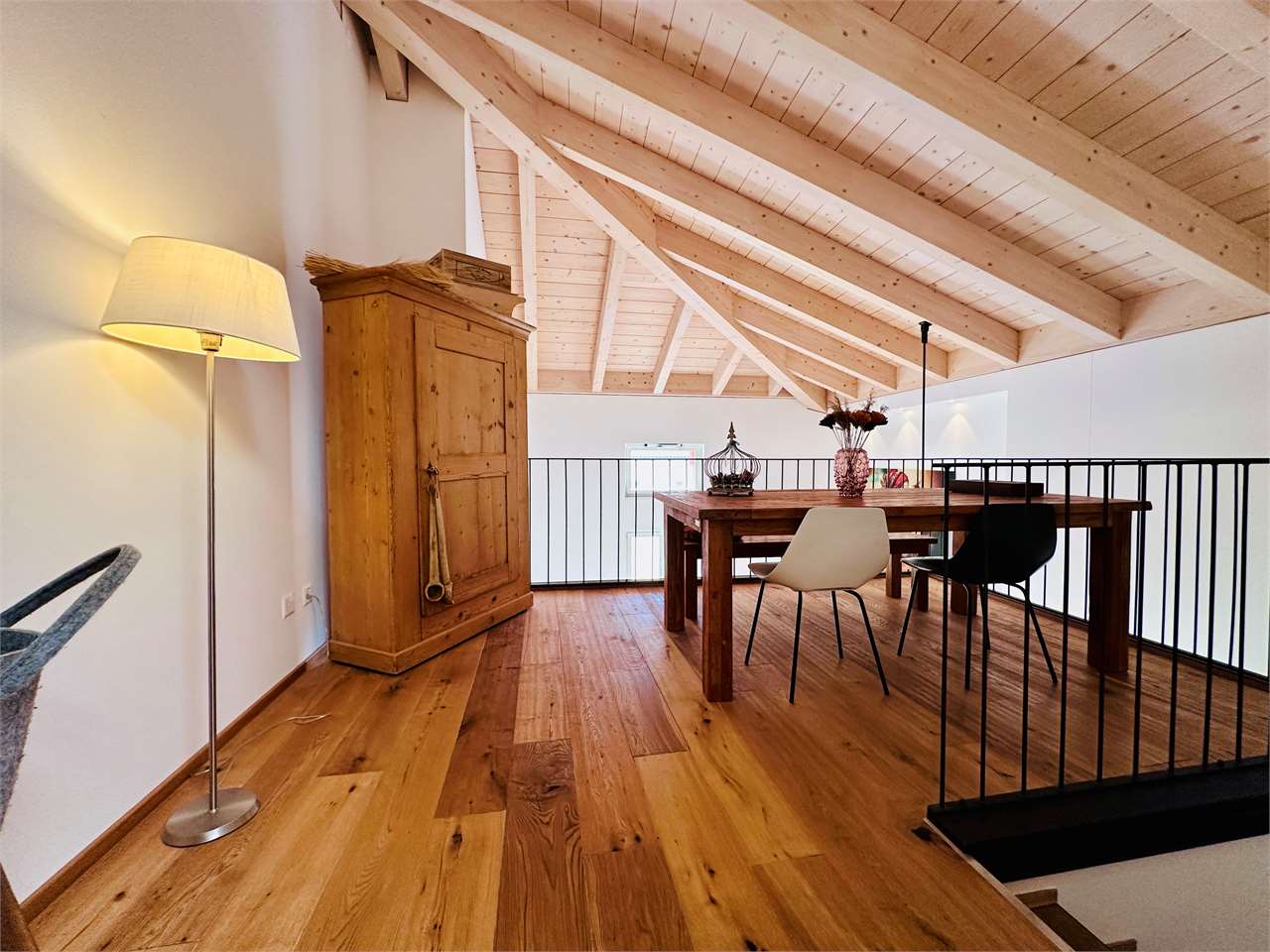 Galerie mit Dachbalken und Holzmöbeln