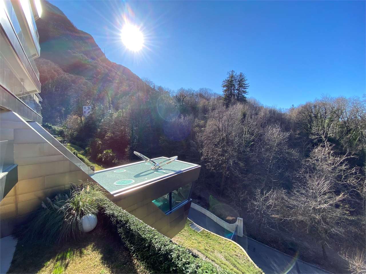 Bergseitige Außenansicht mit moderner Architektur und Gartenblick