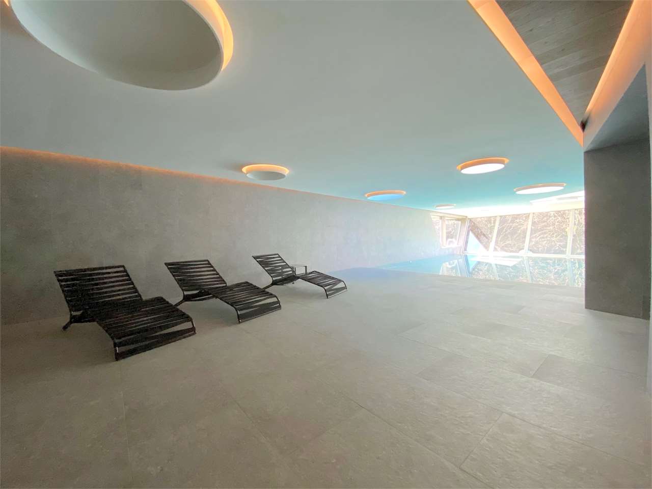Indoor-Poolbereich mit Liegen
