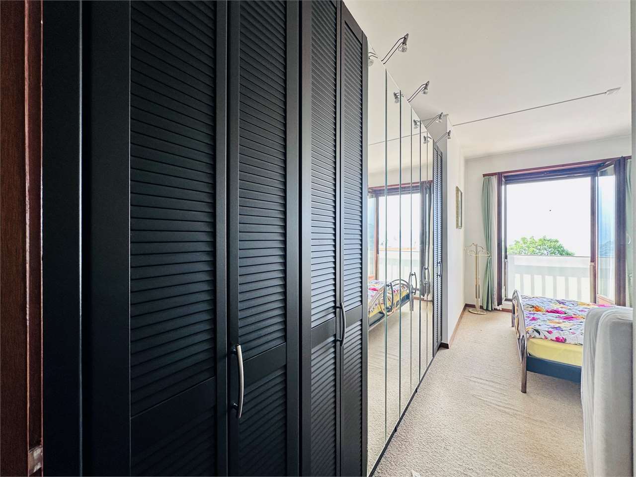 Schlafzimmer mit Einbauschrank und Balkonzugang