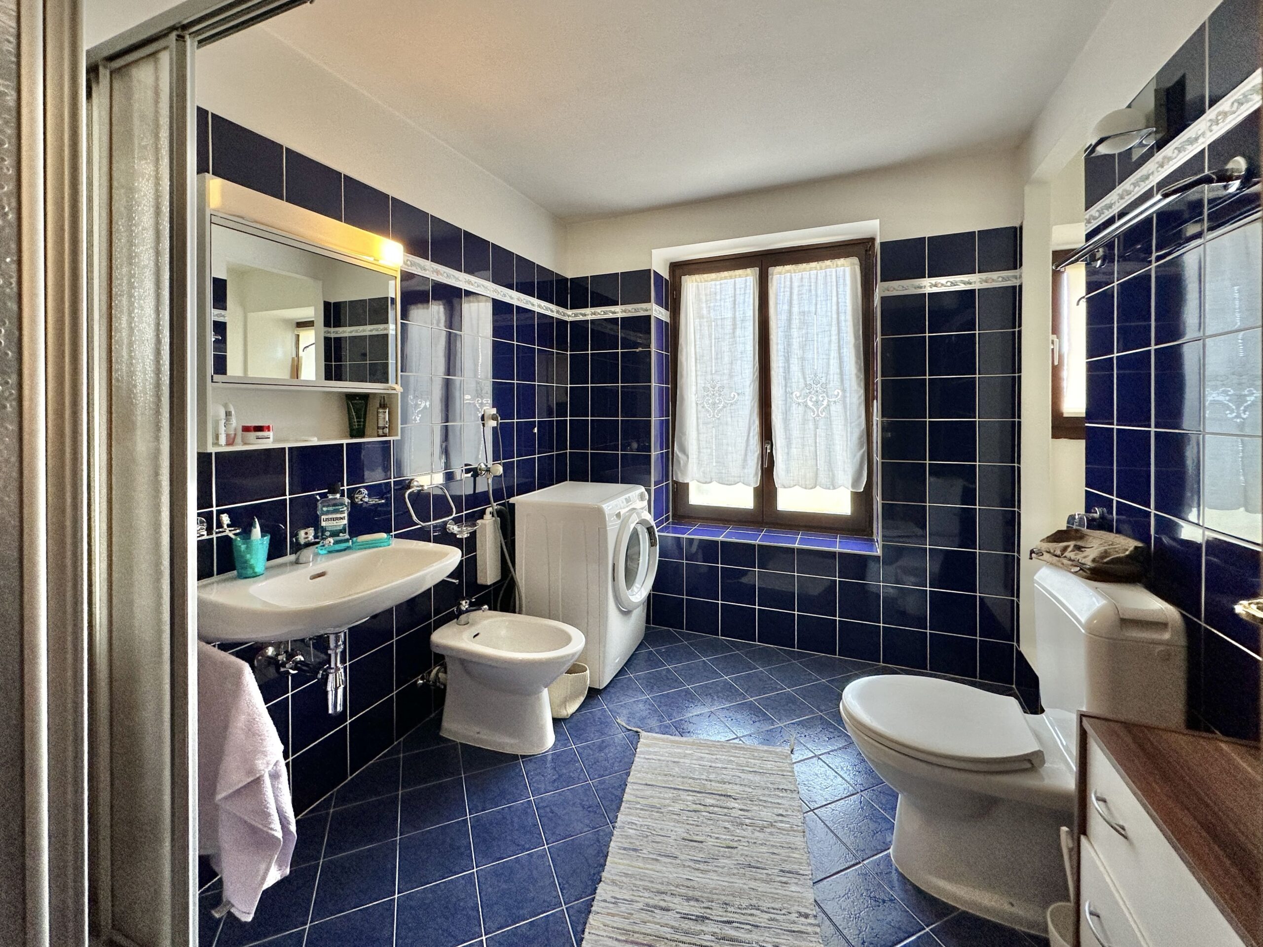 Badezimmer mit dunkelblauen Fliesen