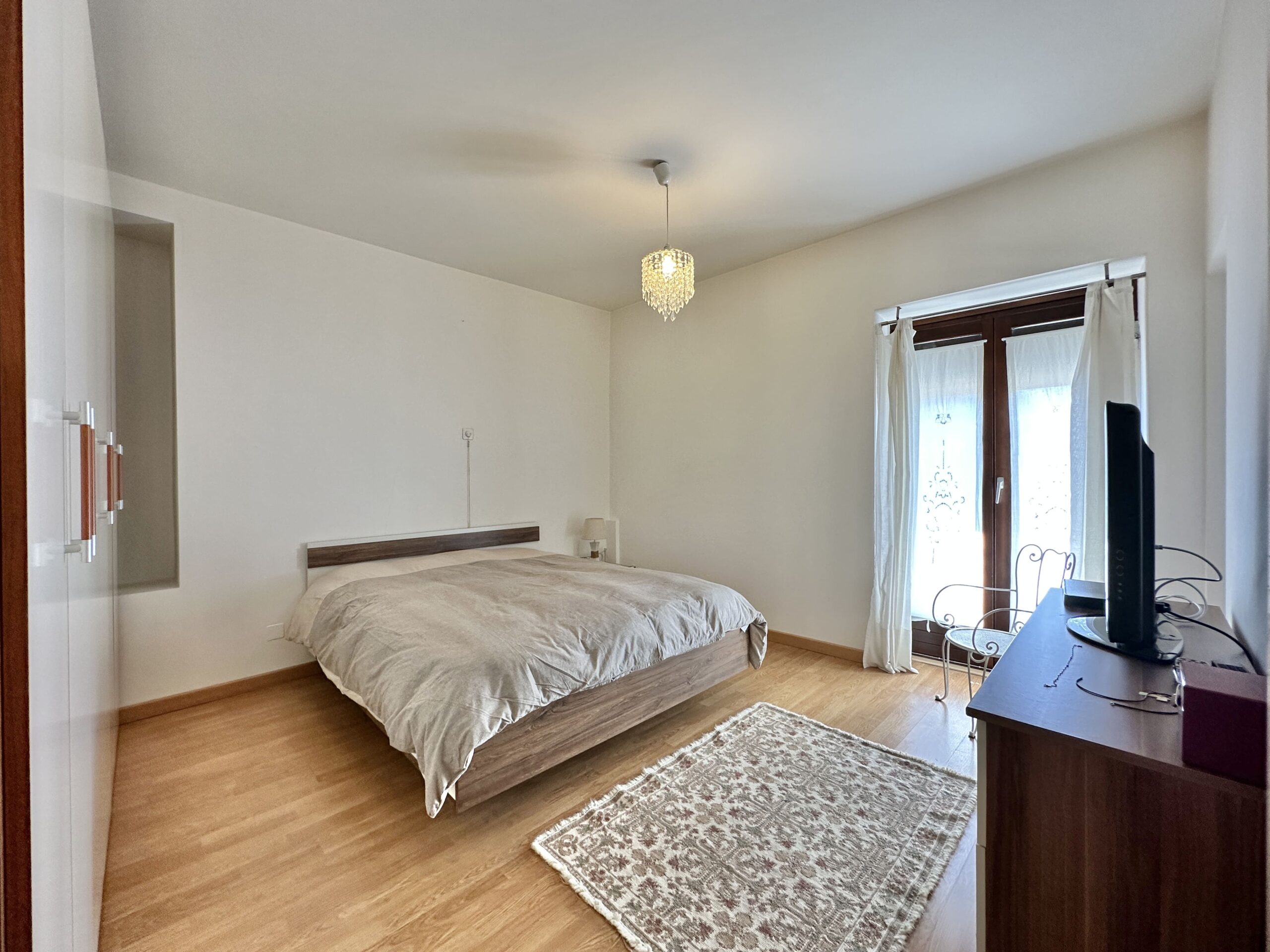 Schlafzimmer mit Doppelbett und Balkonzugang