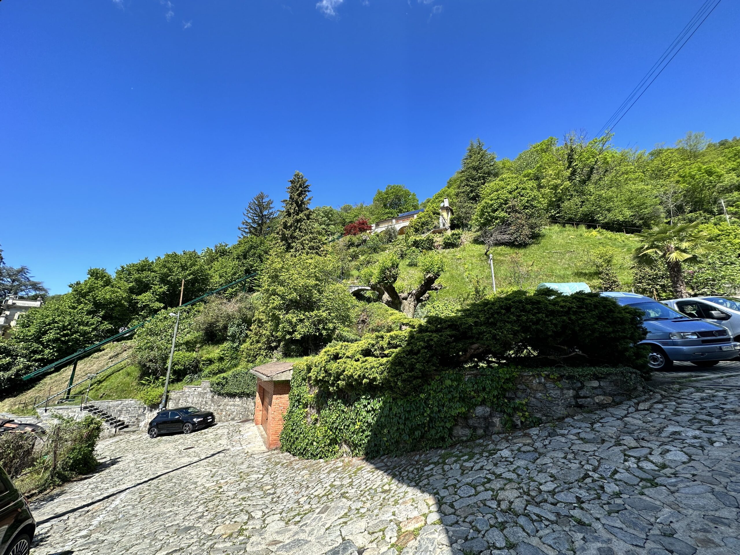Hügelige Zufahrt mit Garten und Parkbereich
