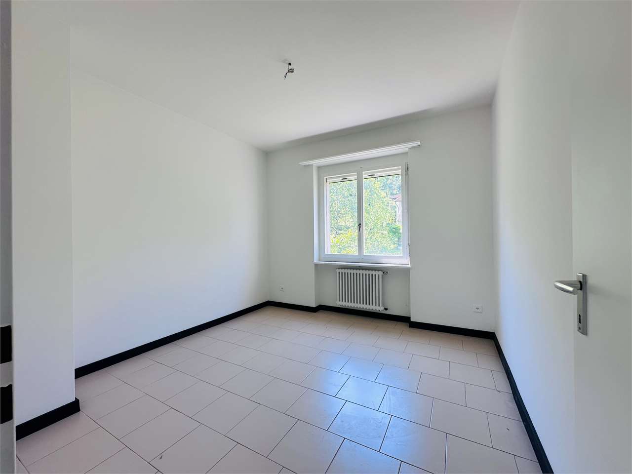 Leerer heller Raum mit Fenster und Heizkörper