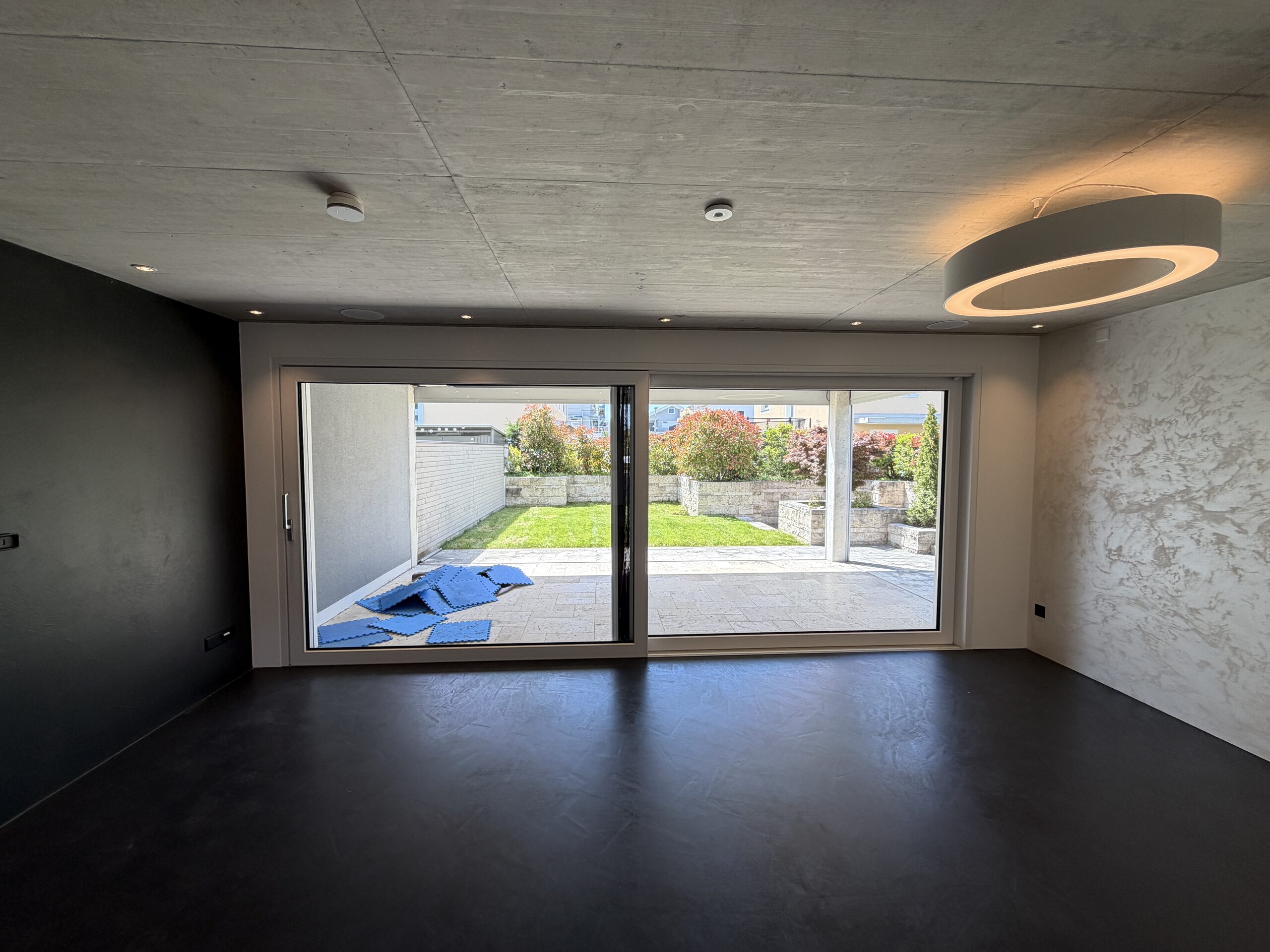 Modernes Wohn-/Esszimmer mit großer Glasfront zum Garten