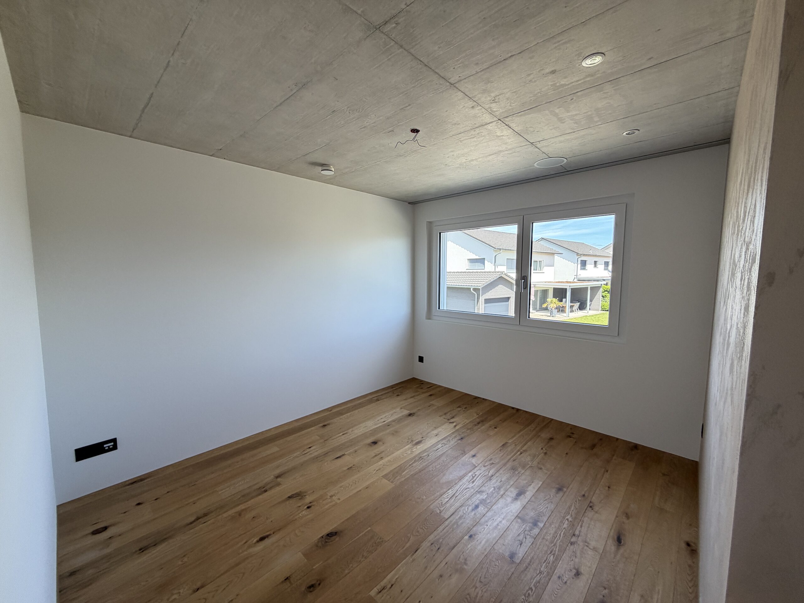 Leerer moderner Raum mit Holzparkett und Fenster