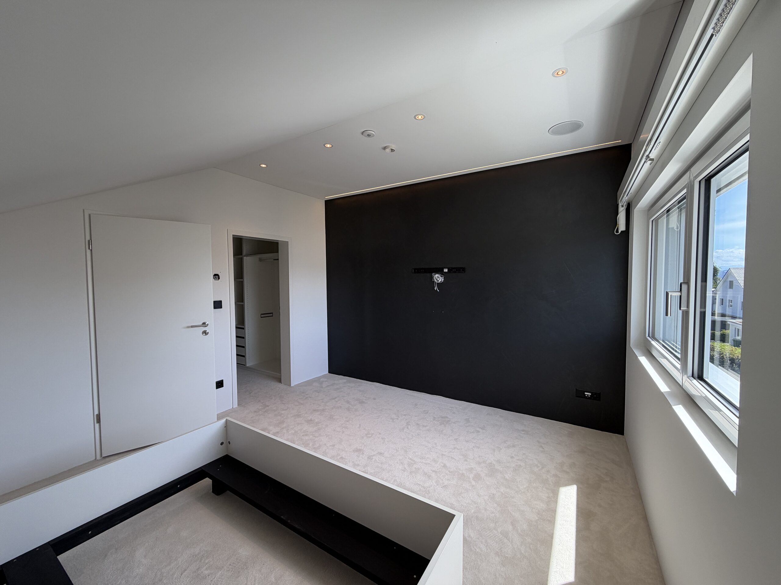 Modernes, fast leeres Schlafzimmer mit Dachfenstern