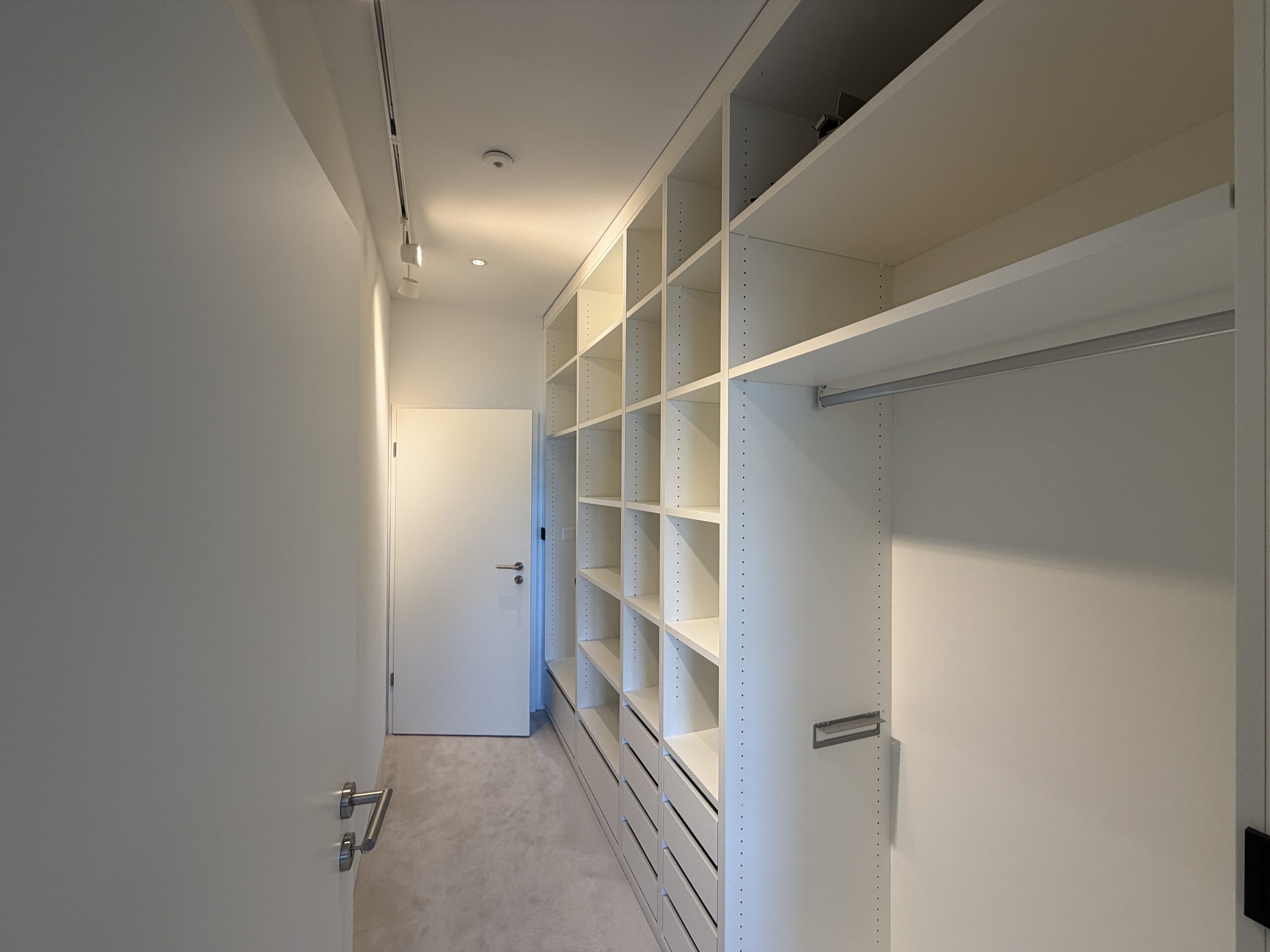 Ankleidezimmer mit weißen Regalen