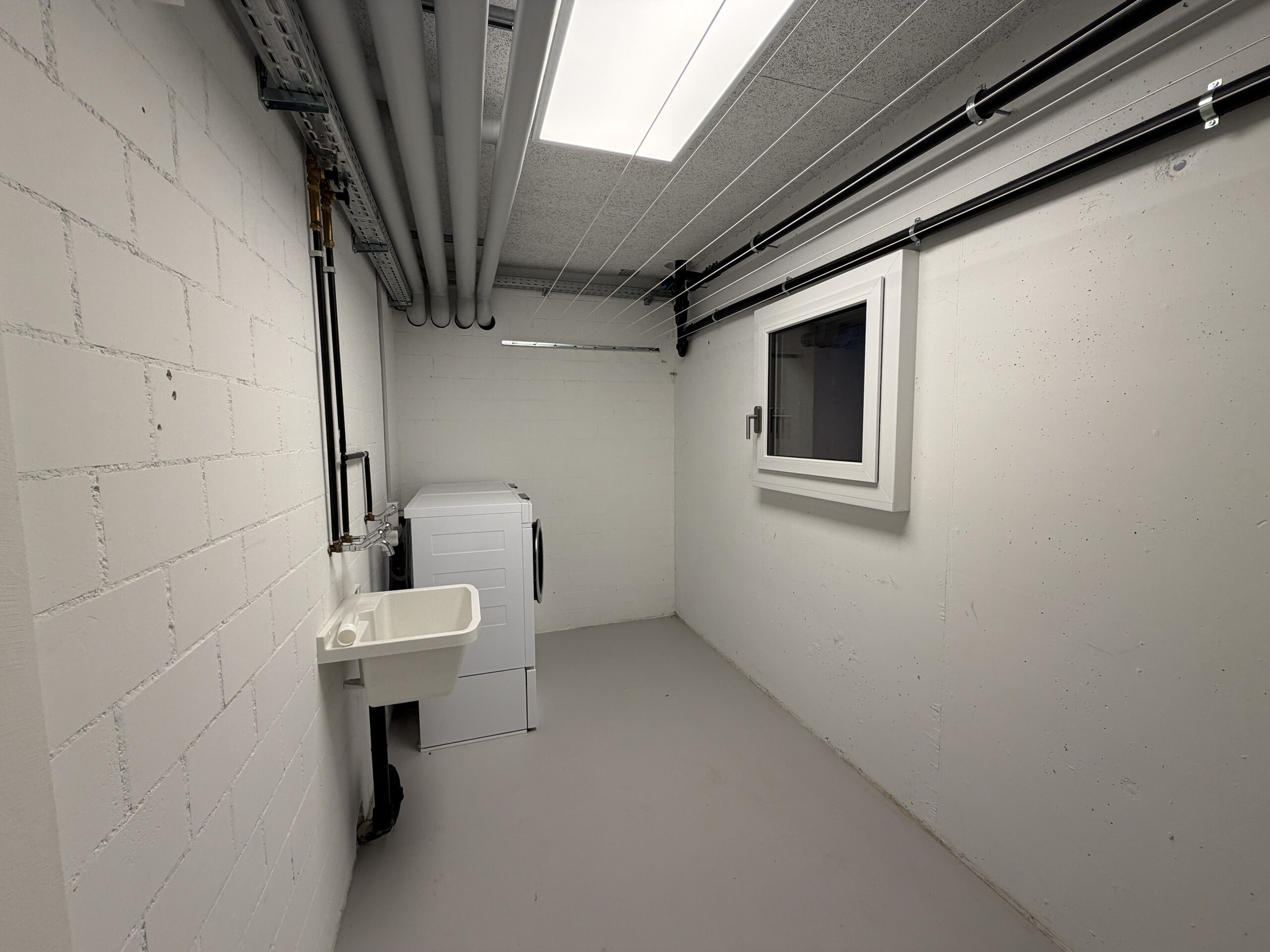 Hauswirtschafts-/Technikraum mit Waschbecken und Gerät