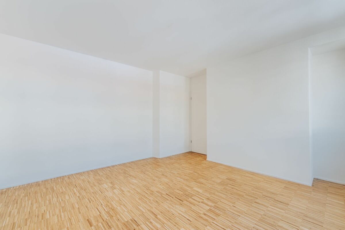 Leerer, heller Innenraum mit Holzoptik-Boden