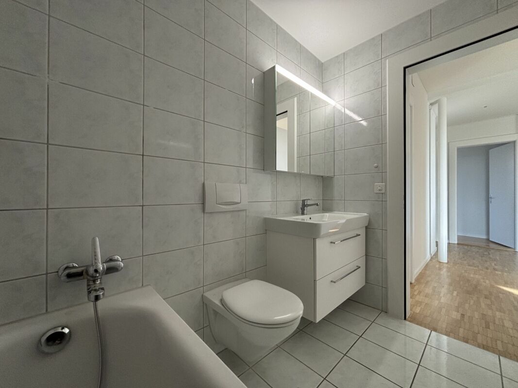 Modernes Badezimmer mit heller Fliesenverkleidung