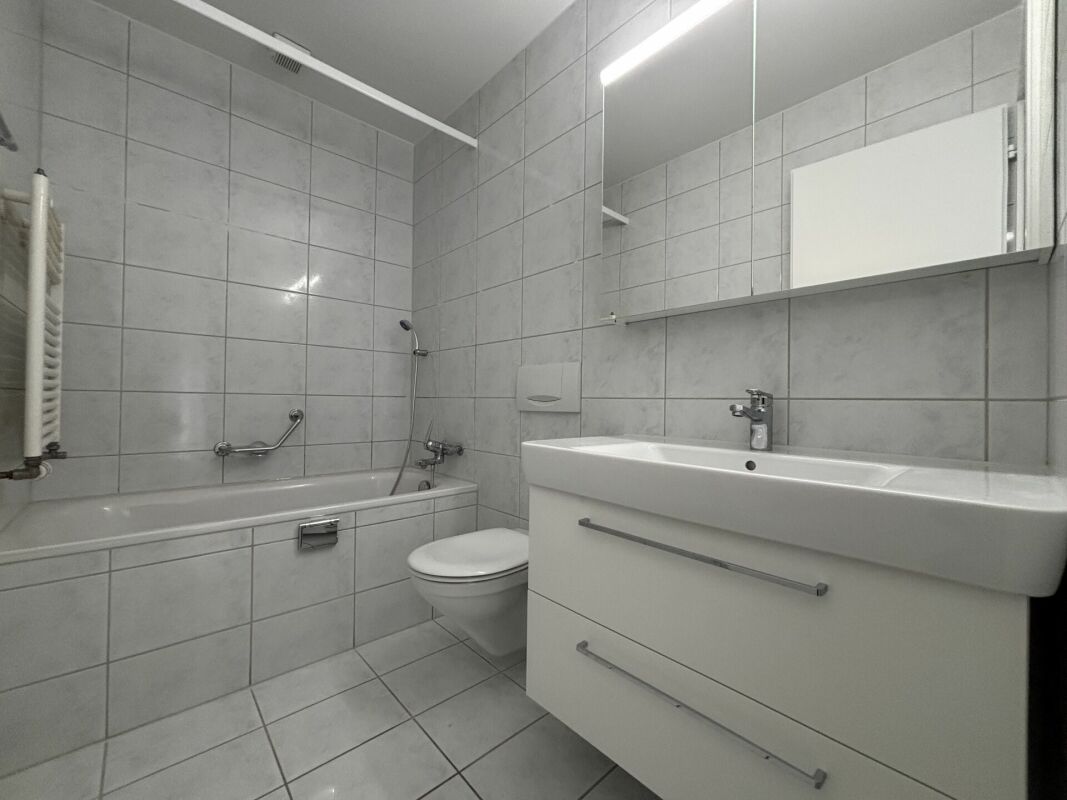 Helles Badezimmer mit Badewanne und Waschtisch