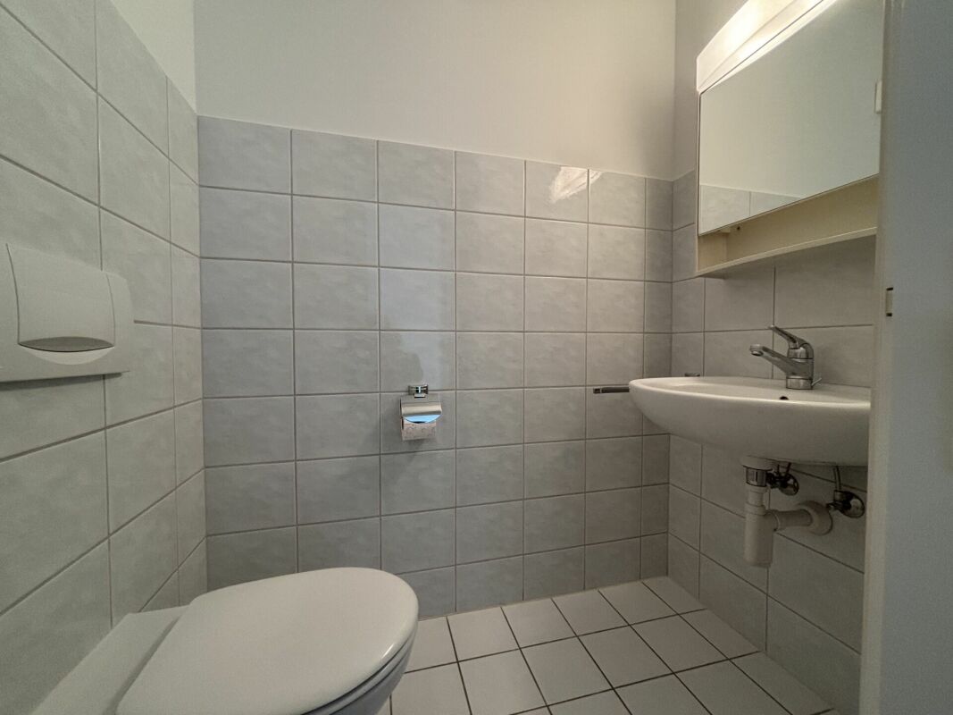 Kleines Gäste-WC mit Wandfliesen und Handwaschbecken