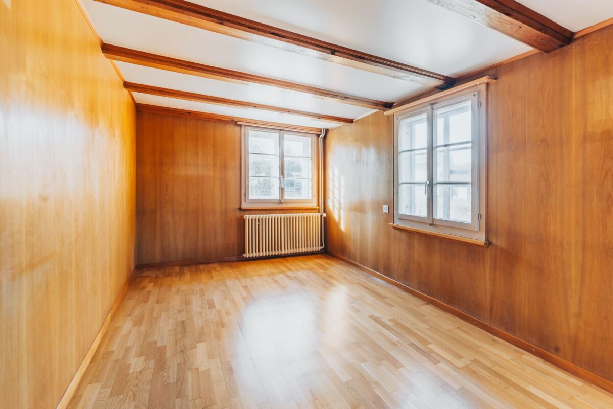 Holzverkleideter Raum mit Fenstern und Heizkörper