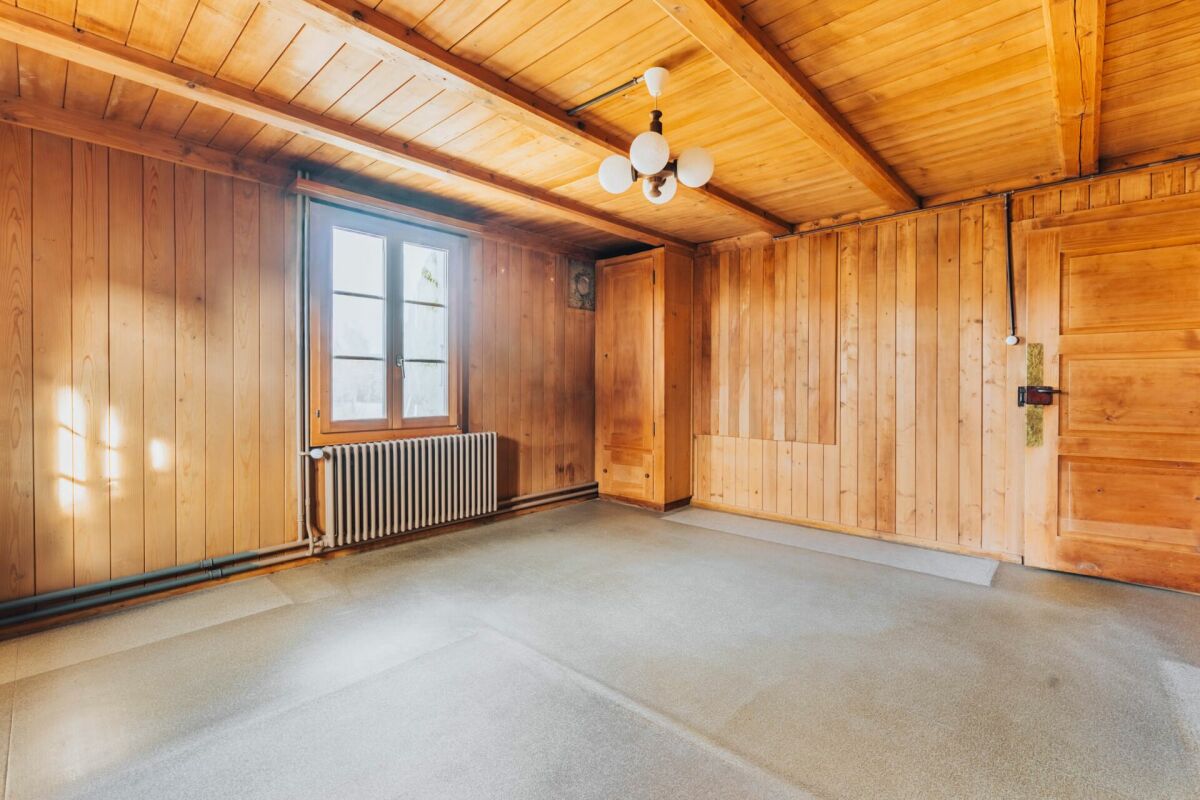 Holzvertäfelter Raum mit Fenster und Heizkörper