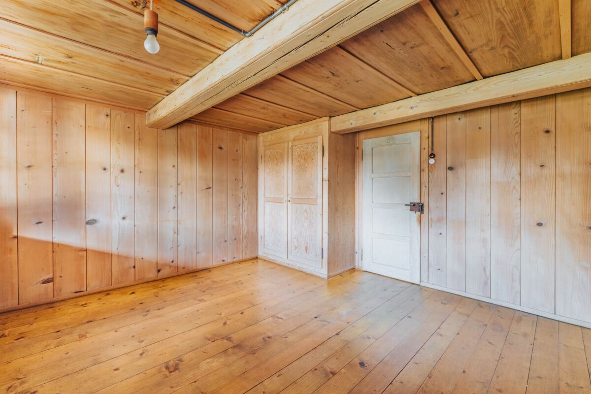 Holzverkleideter Raum mit sichtbaren Balken