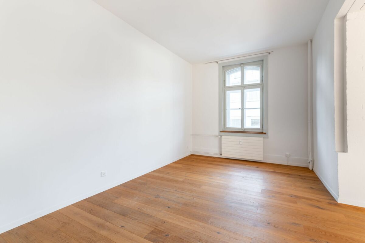Leerer heller Raum mit Holzboden und Fenster