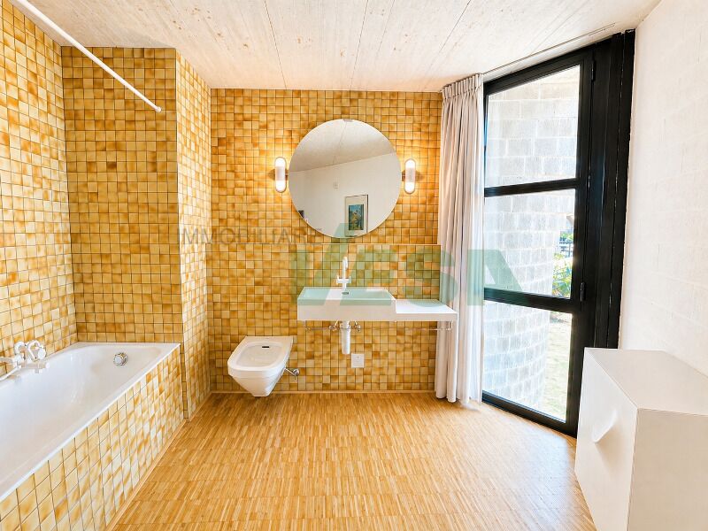 Badezimmer mit gelb-oranger Fliesenoptik