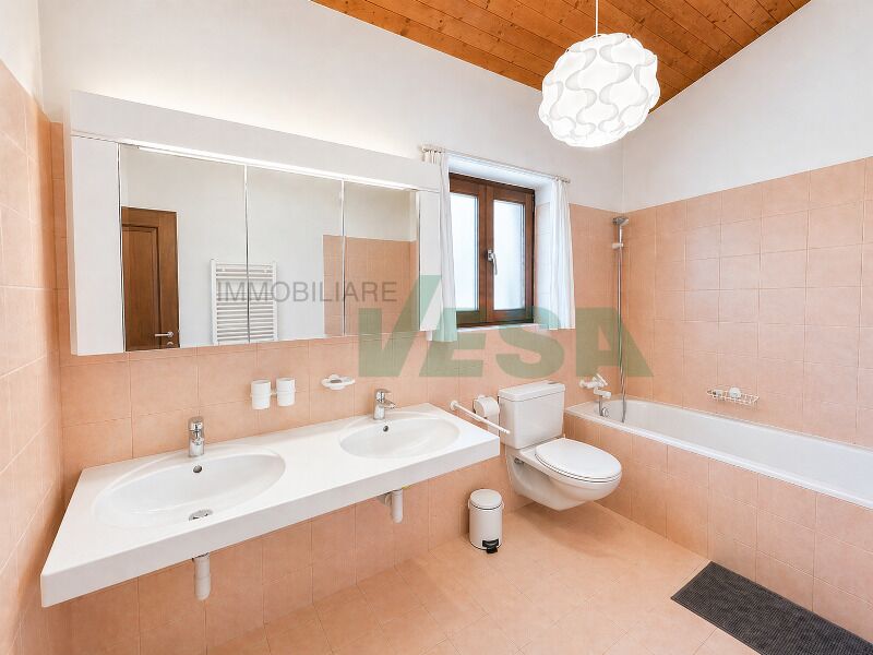Helles Badezimmer mit Doppelwaschtisch und Wanne