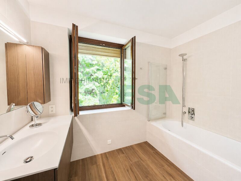 Helles Badezimmer mit Badewanne und Fenster