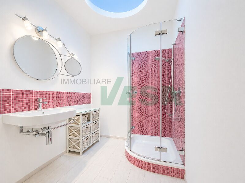 Helles Badezimmer mit runder Dusche und Doppelspiegel