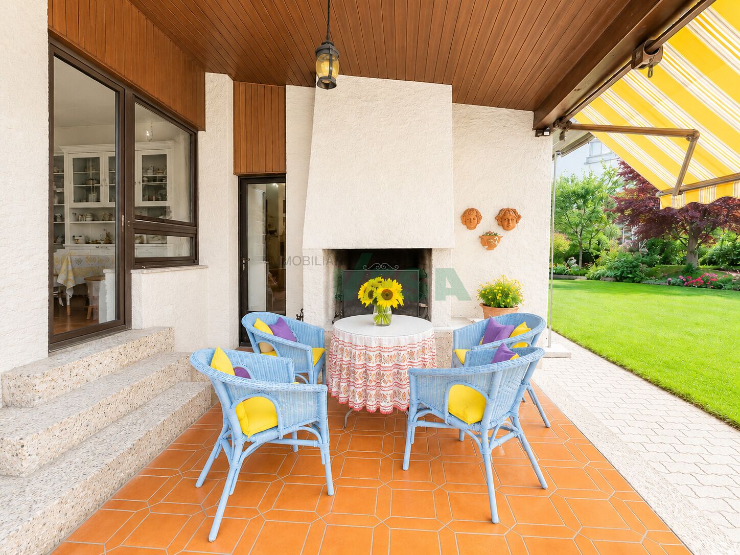 Überdachte Terrasse mit Sitzgruppe und Kamin
