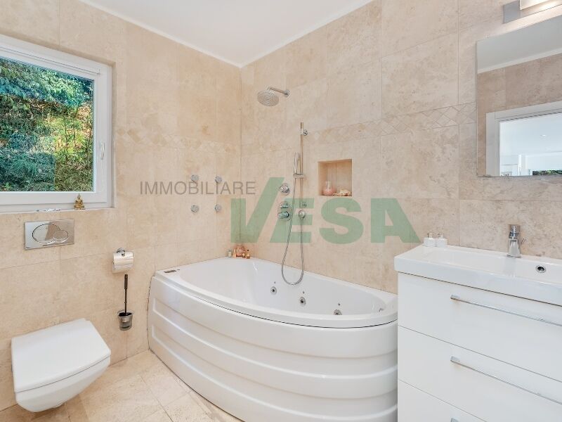 Helles Badezimmer mit Eckbadewanne und Fenster