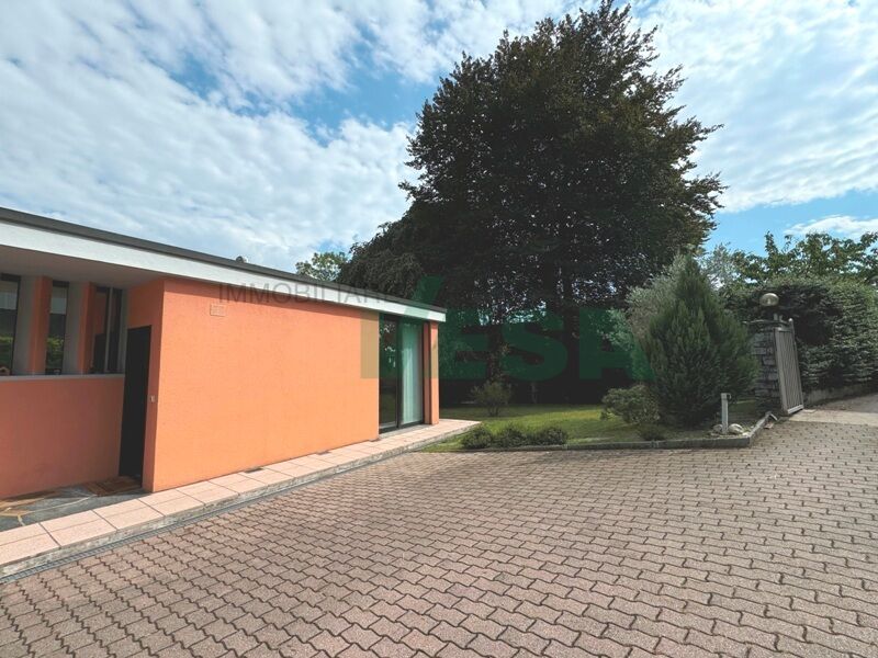 Flaches Wohngebäude mit Zufahrt und Garten