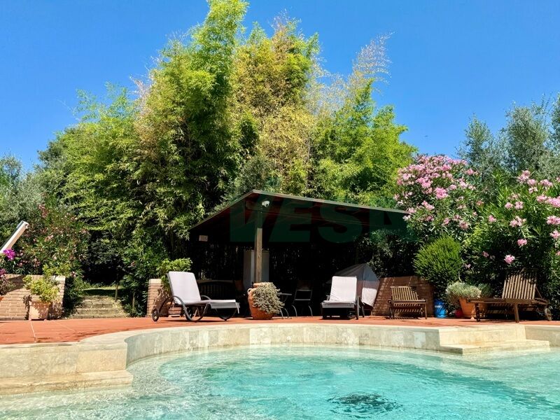 Poolbereich im Garten mit überdachtem Sitzplatz