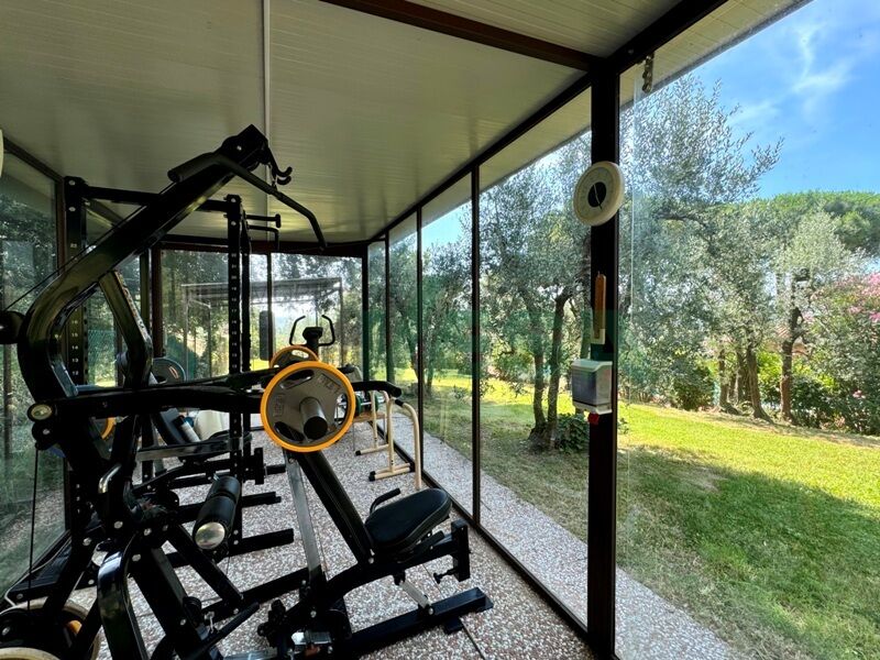Fitnessraum mit Glaswänden zum Garten