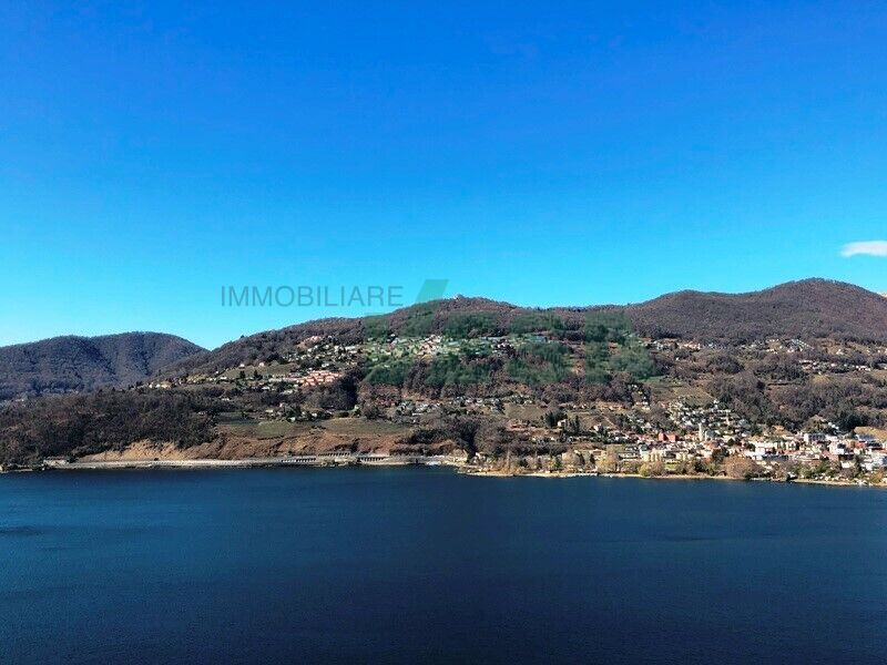 Seenlandschaft mit Bergen und Ortschaft am Wasser