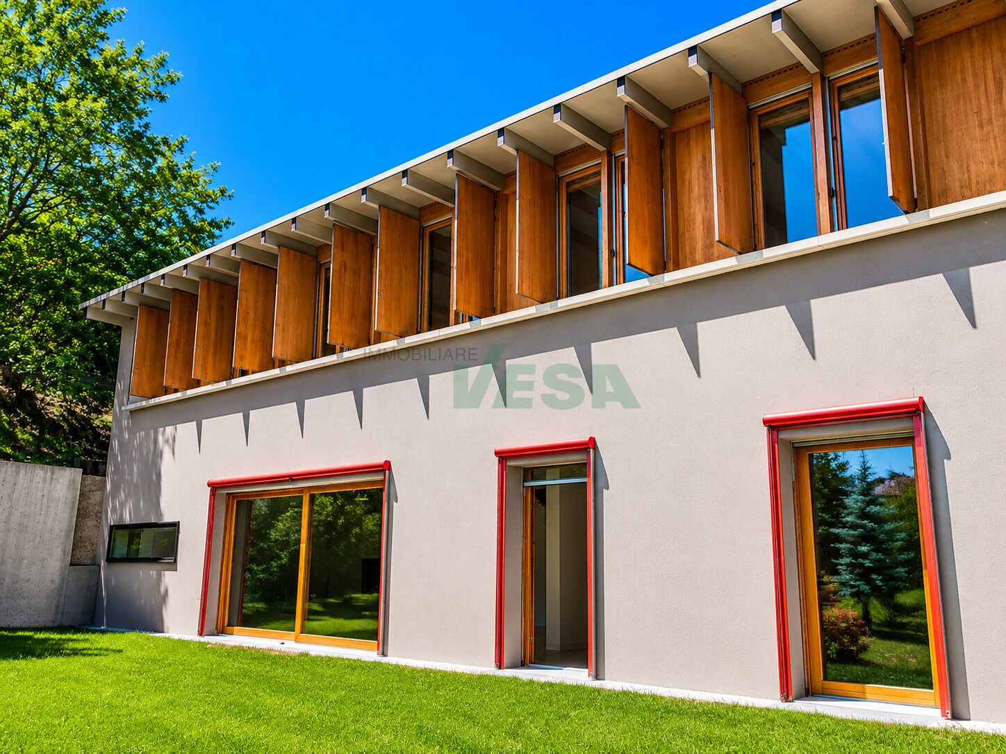 Modernes Gebäude mit Holzlamellen und großen Fenstern