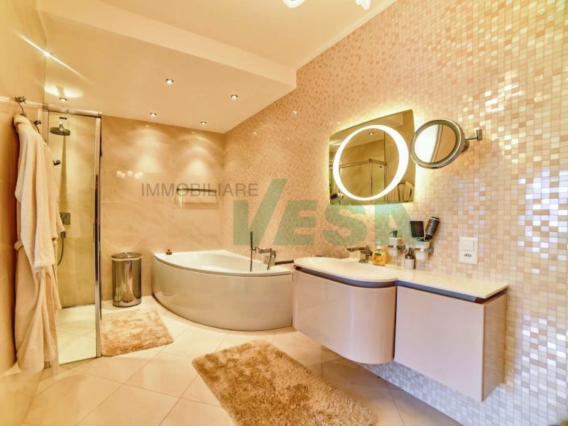 Modernes Badezimmer mit Wanne und Mosaikwand