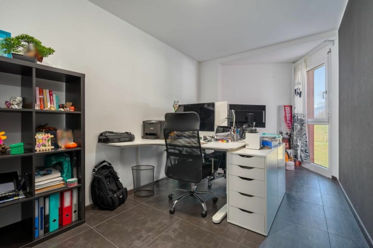 Arbeitszimmer mit Schreibtisch und Regal