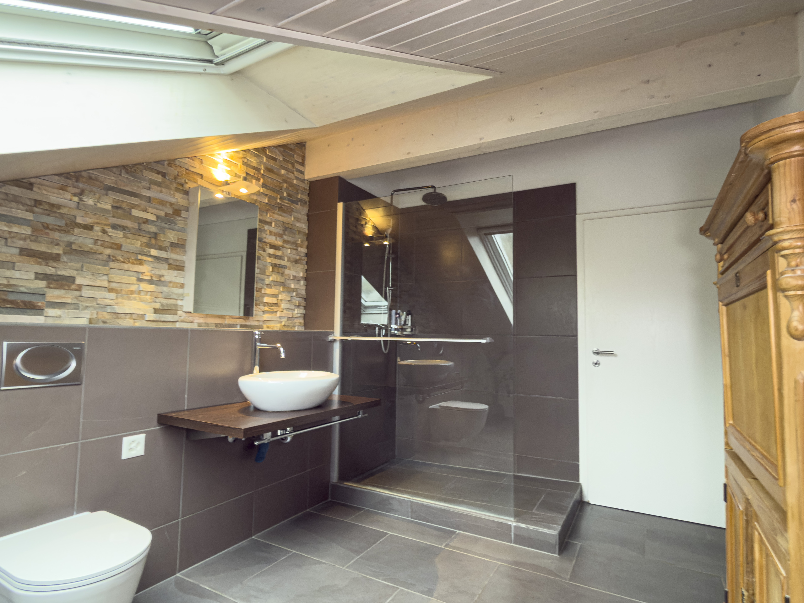 Modernes Bad mit begehbarer Dusche und Natursteinakzentwand